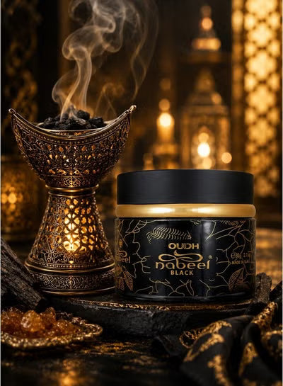 A jar of Nabeel Black Oudh incense powder sits next to an ornate bronze incense burner with rising smoke, set against a warm, golden bokeh background of lanterns.
