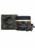 A jar of Oudh Nabeel Black with its matching outer box and a few dark dried flower buds, displayed on a clean white background.