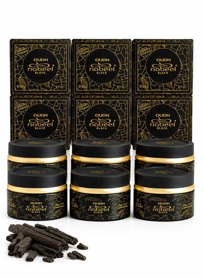 Six black jars of Qudh Nabeel Black with gold lids are arranged in front of six matching black and gold boxes. A few loose dark brown cinnamon sticks are placed in the lower left on a clean white background.